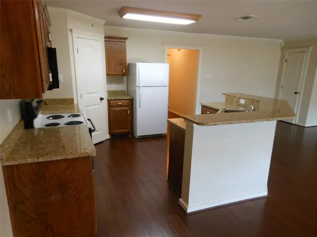 a kitchen with a refrigerator and a stove top oven