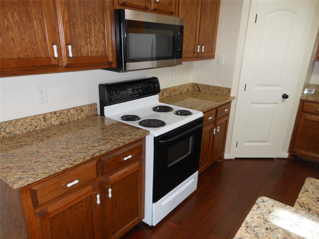 206 Highway 342, Unit K Red Oak, TX 75154 - Photo 10 of 14 a kitchen with granite countertop a stove and a microwave