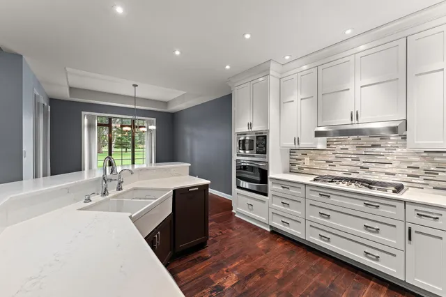 a kitchen with stainless steel appliances kitchen island granite countertop a sink and cabinets