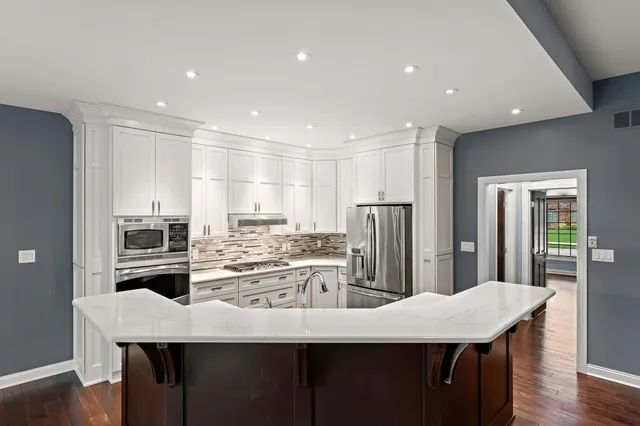 a kitchen with refrigerator cabinets and wooden floor