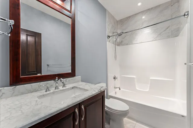 a bathroom with a granite countertop sink toilet and shower