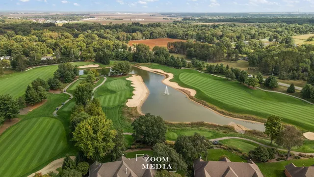 an aerial view of a house with yard swimming pool and lake view