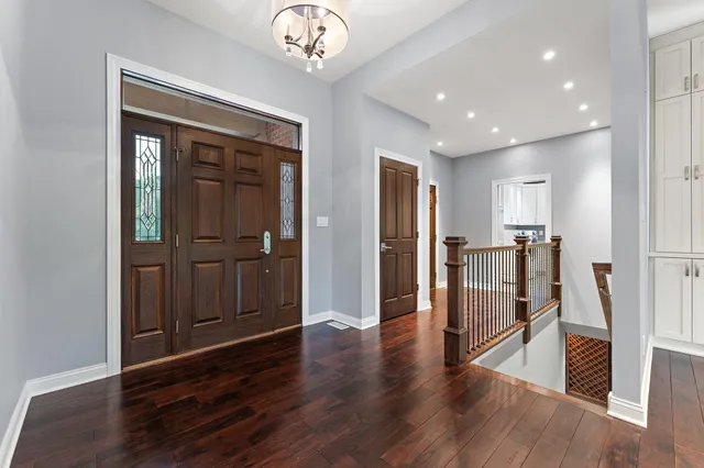 a view of a hallway with wooden floor and a kitchen