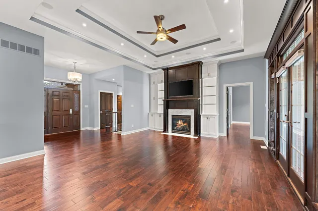 a view of empty room with wooden floor and a ceiling fan