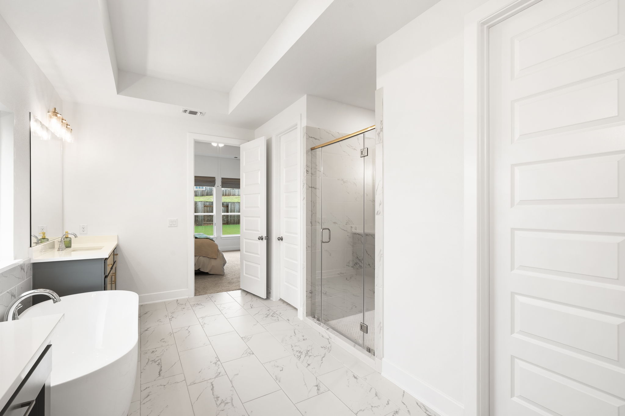 515 Watershield Cove Georgetown, TX 78633 - Photo 20 of 40 Luxurious primary bathroom retreat featuring a free-standing tub, separate shower, and elegant tile flooring.