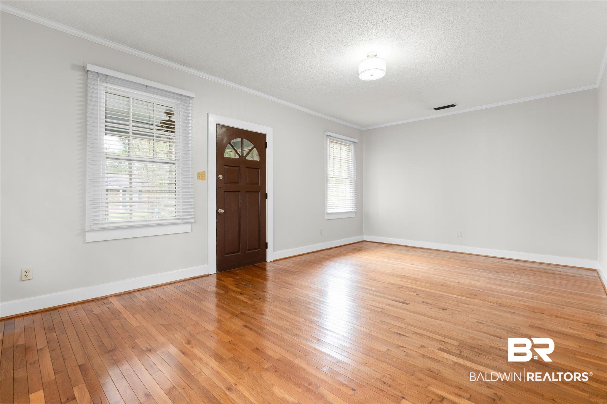 211 3rd Street Mobile, AL 36611 - Photo 4 of 20 Entryway featuring a textured ceiling, light wood-type flooring, and ornamental molding