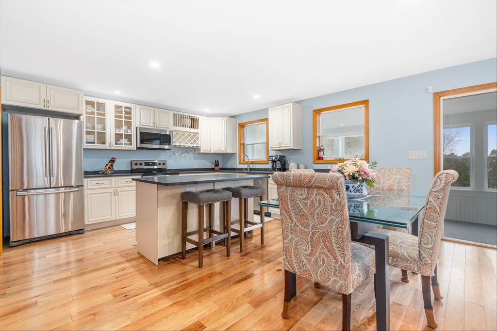 97 3rd Street North Edgartown, MA 02539 - Photo 16 of 27 a kitchen with stainless steel appliances kitchen island granite countertop a refrigerator a stove a kitchen island with chairs and wooden floor