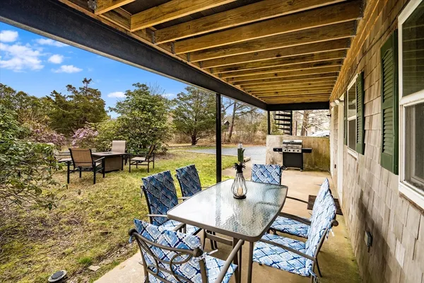 a roof deck with table and chairs and potted plants