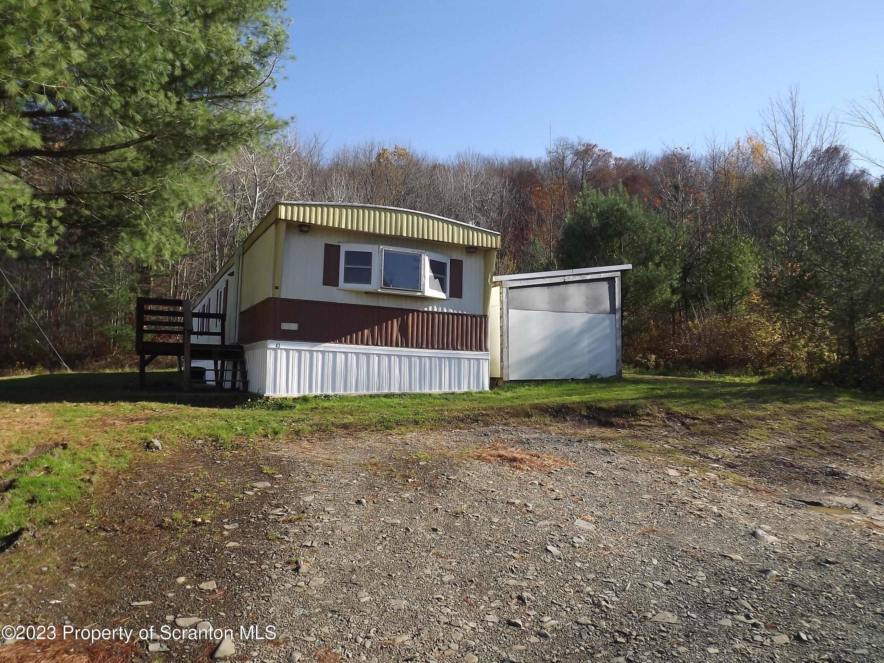 940 Nowlan Road, Unit 43 Port Crane, NY 13833 - Photo 1 of 13 a front view of a house with a yard and garage