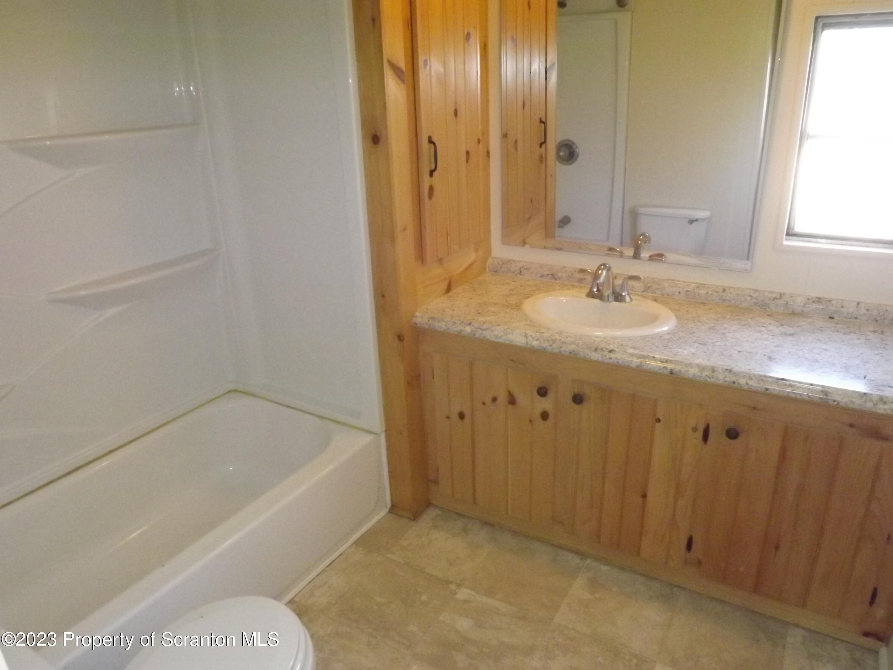 940 Nowlan Road, Unit 43 Port Crane, NY 13833 - Photo 11 of 13 a bathroom with a granite countertop sink and a bathtub