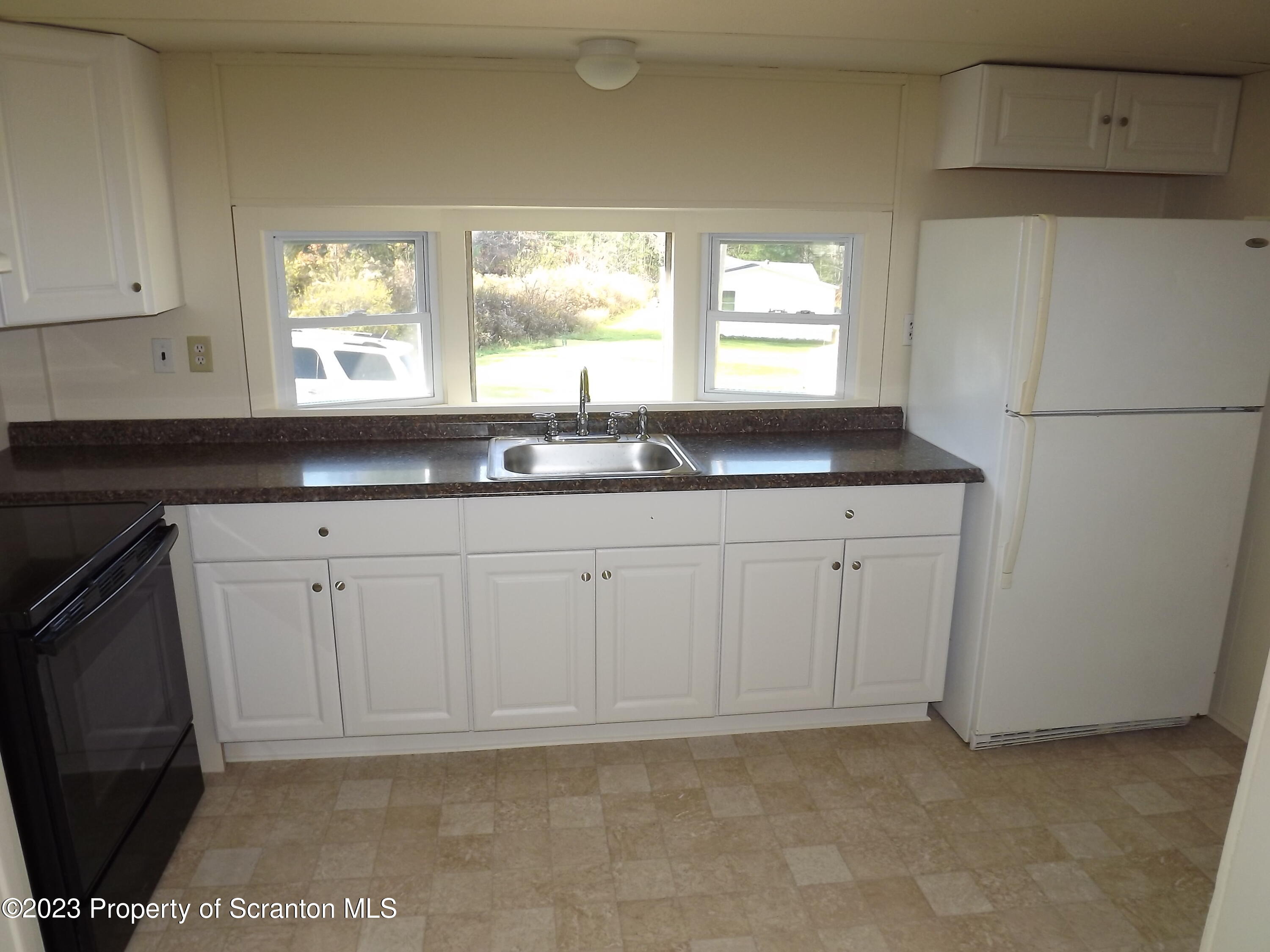 940 Nowlan Road, Unit 43 Port Crane, NY 13833 - Photo 7 of 13 a kitchen with granite countertop a sink a window and a granite counter tops