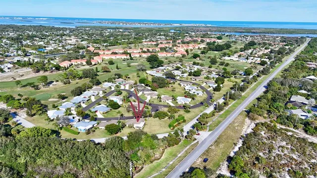 an aerial view of residential houses with outdoor space and trees all around
