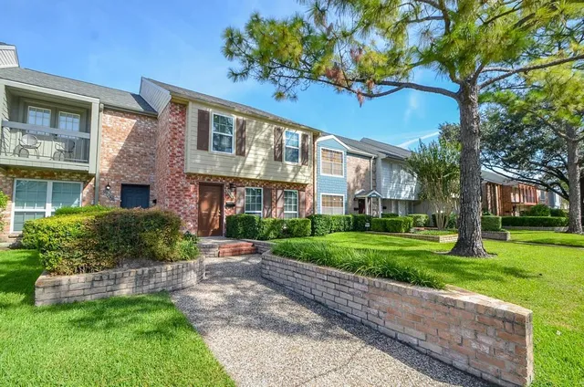 a front view of a house with a yard and potted plants