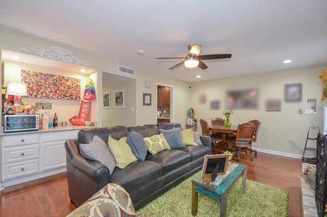 a living room with furniture a ceiling fan and a window