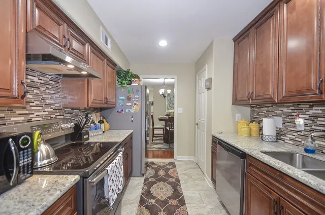 a kitchen with stainless steel appliances granite countertop a sink stove and refrigerator