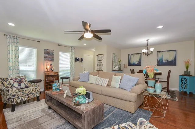 a living room with furniture kitchen view and a chandelier