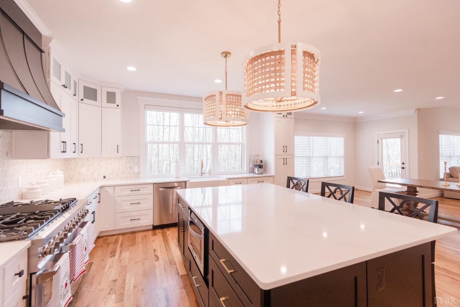 1401 Smartview Lane Forest, VA 24551 - Photo 17 of 46 a large kitchen with kitchen island a stove a sink a dining table and chairs with wooden floor