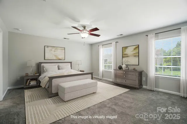 a spacious bedroom with a large bed and a chandelier