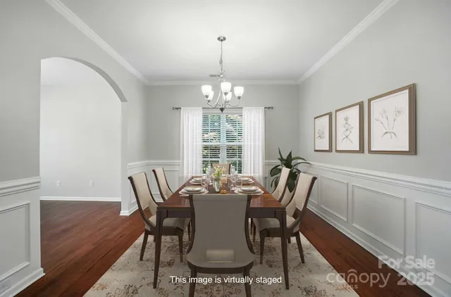 a view of a dining room with furniture a chandelier and wooden floor