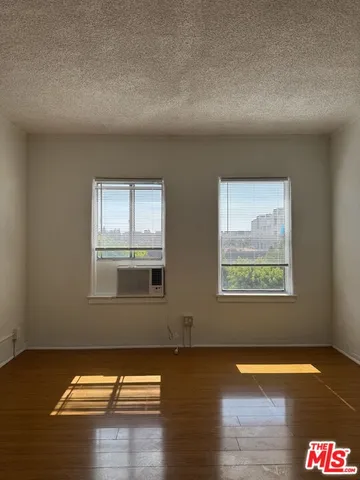 a view of a livingroom with wooden floor and a window