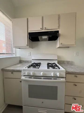 a stove top oven sitting inside of a kitchen