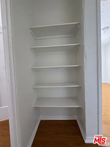 a view of walk in closet with empty racks