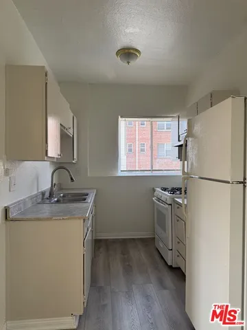 a kitchen with stainless steel appliances granite countertop a refrigerator sink and stove