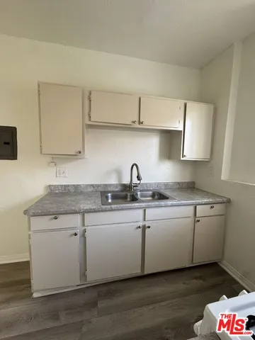 a kitchen with granite countertop a sink a stove and cabinets