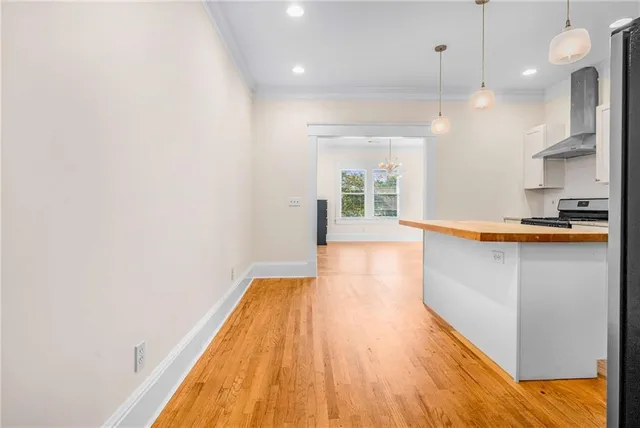 a view of hallway with wooden floor and a chandelier