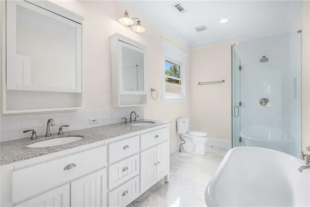 a spacious bathroom with a granite countertop double vanity sink mirror and toilet