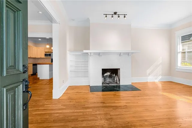 a view of empty room with wooden floor and fireplace
