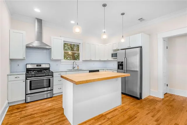 a kitchen with stainless steel appliances granite countertop a sink stove and refrigerator