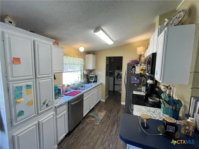 a kitchen with stainless steel appliances granite countertop a refrigerator and a stove