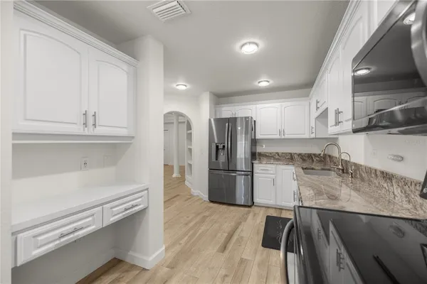 a kitchen with stainless steel appliances granite countertop a stove a sink and a refrigerator