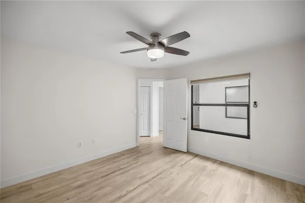a view of a hallway with wooden floor and a window