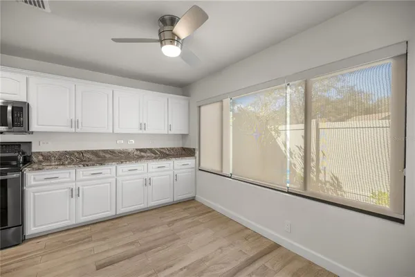a kitchen with granite countertop white cabinets and stainless steel appliances