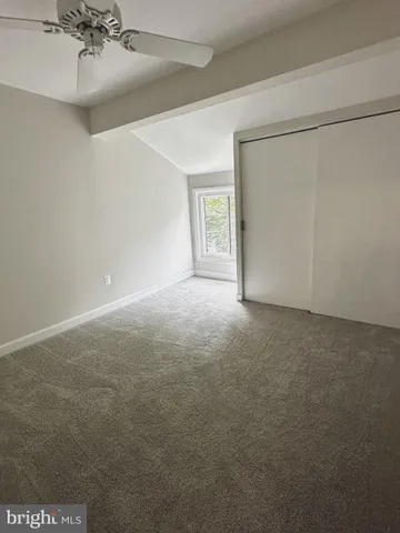 a view of a room with a ceiling fan and a window