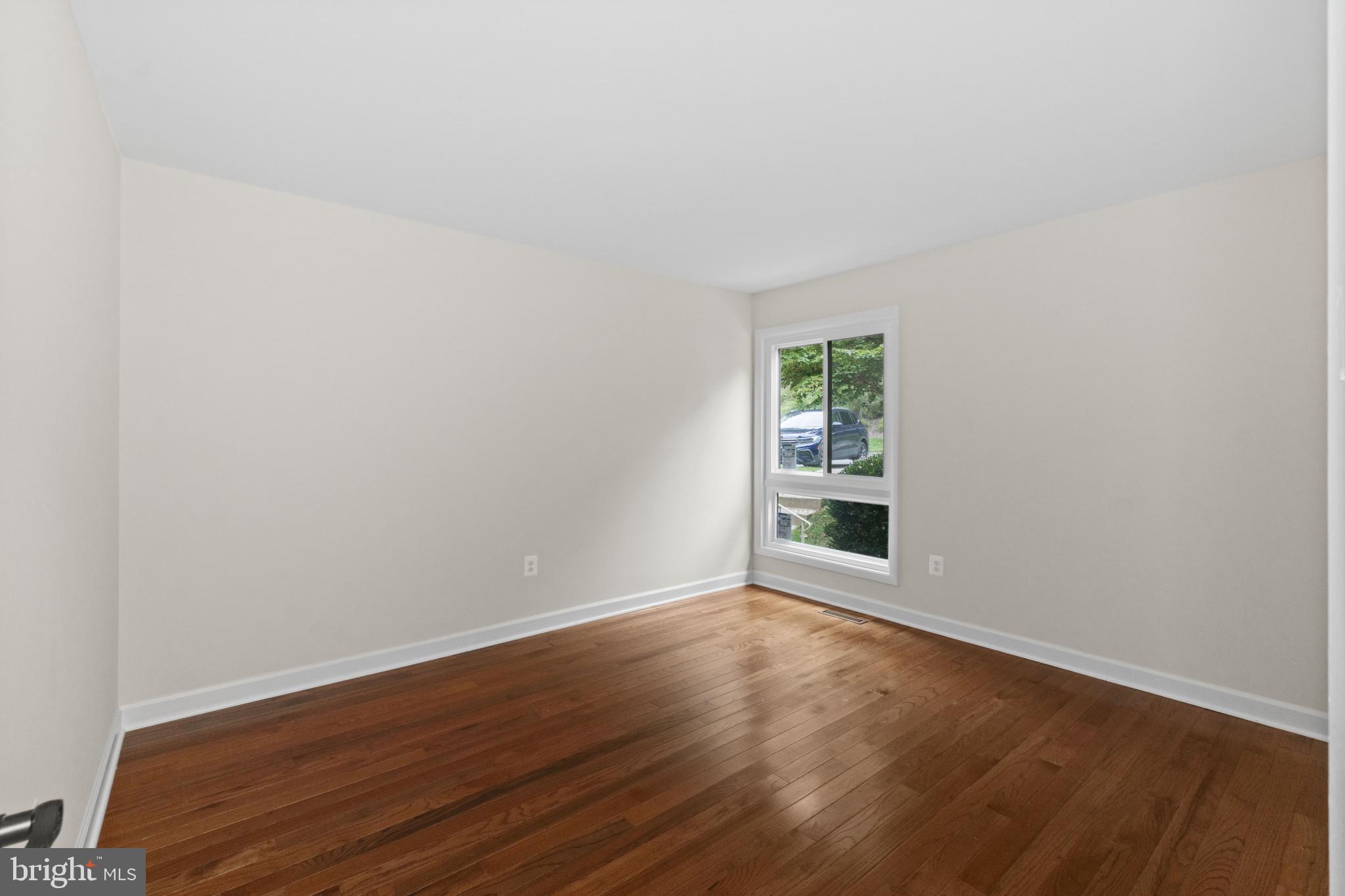 108 Beech Hill Lane, Unit 60 Baltimore, MD 21286 - Photo 16 of 27 a view of an empty room with wooden floor and a window