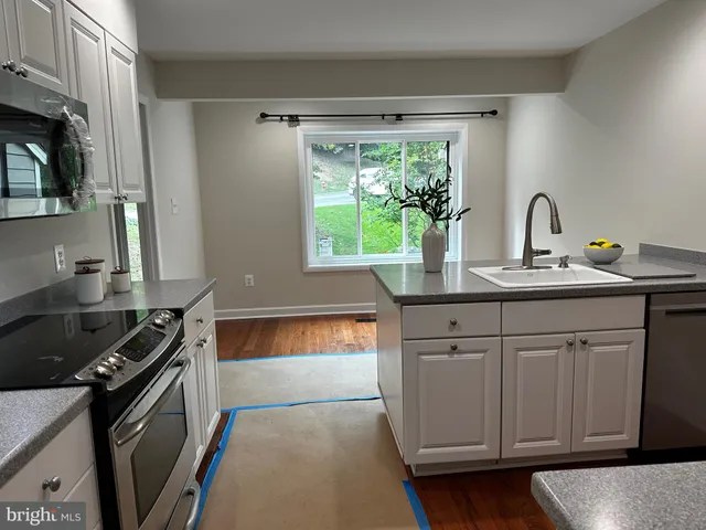 a kitchen with a sink stove and cabinets