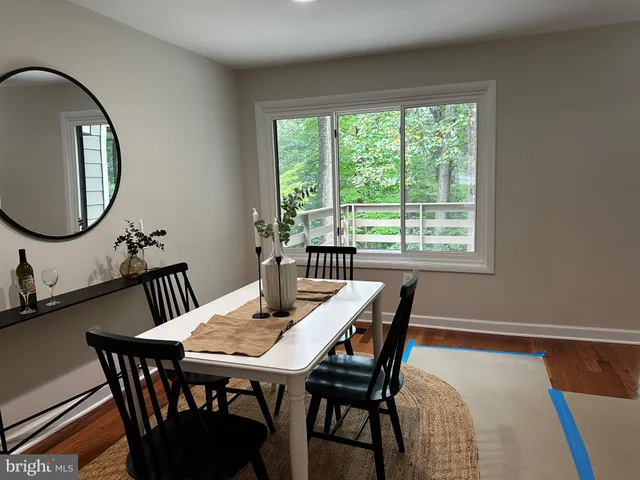 a view of a dining room and hall with a large window