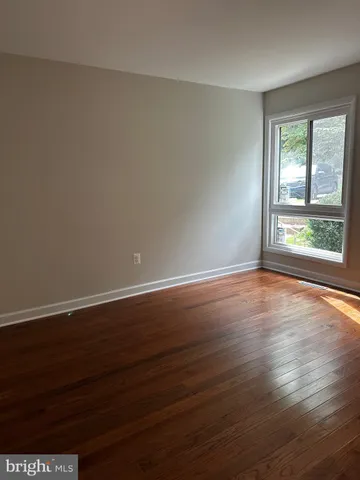 a view of a room with wooden floor and window