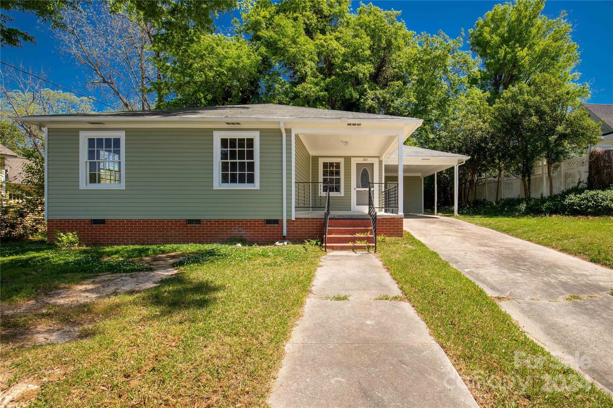a front view of a house with a yard and trees