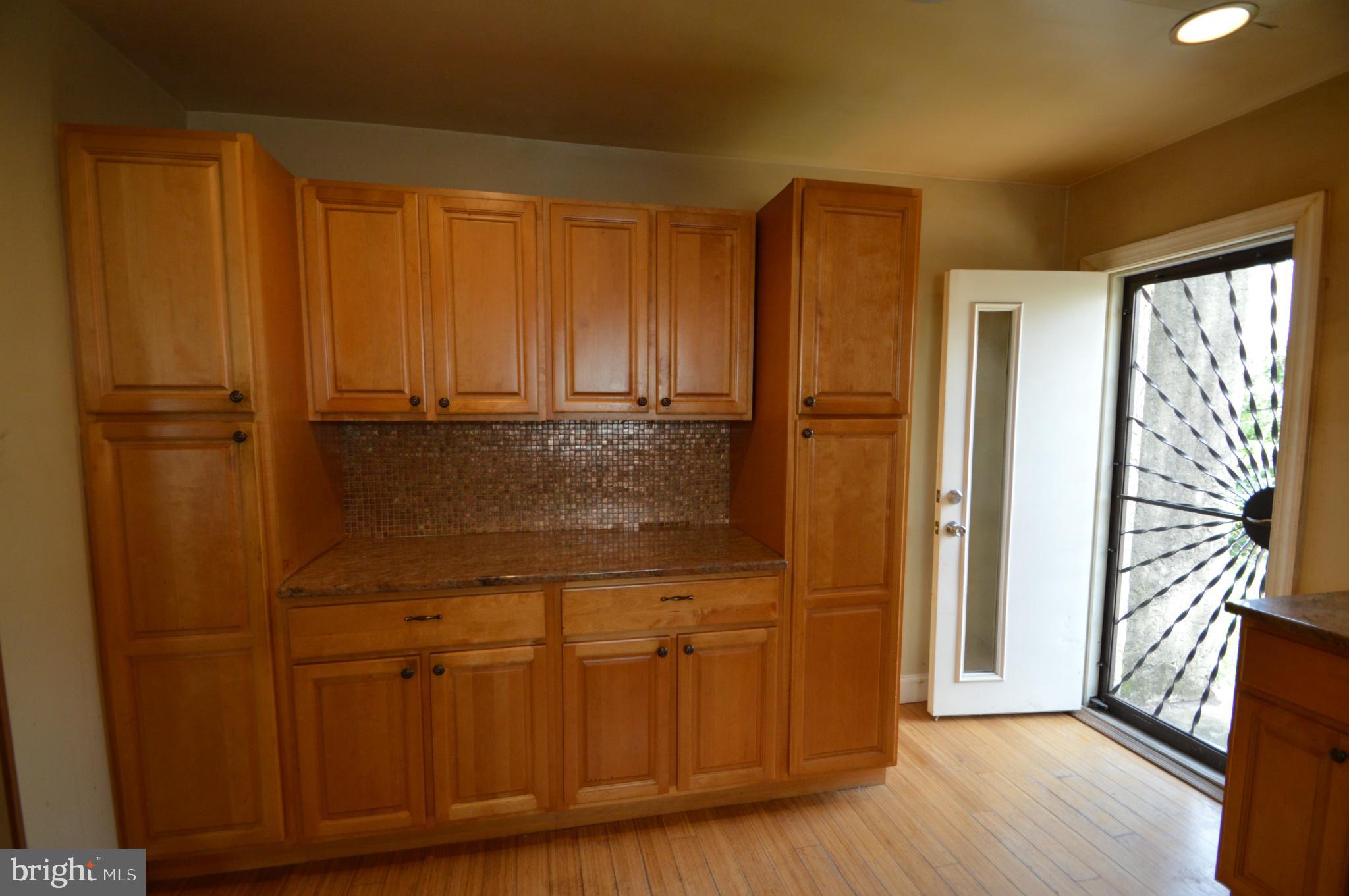 6011 Sansom Street Philadelphia, PA 19139 - Photo 11 of 24 a view of a kitchen with wooden floor and cabinets