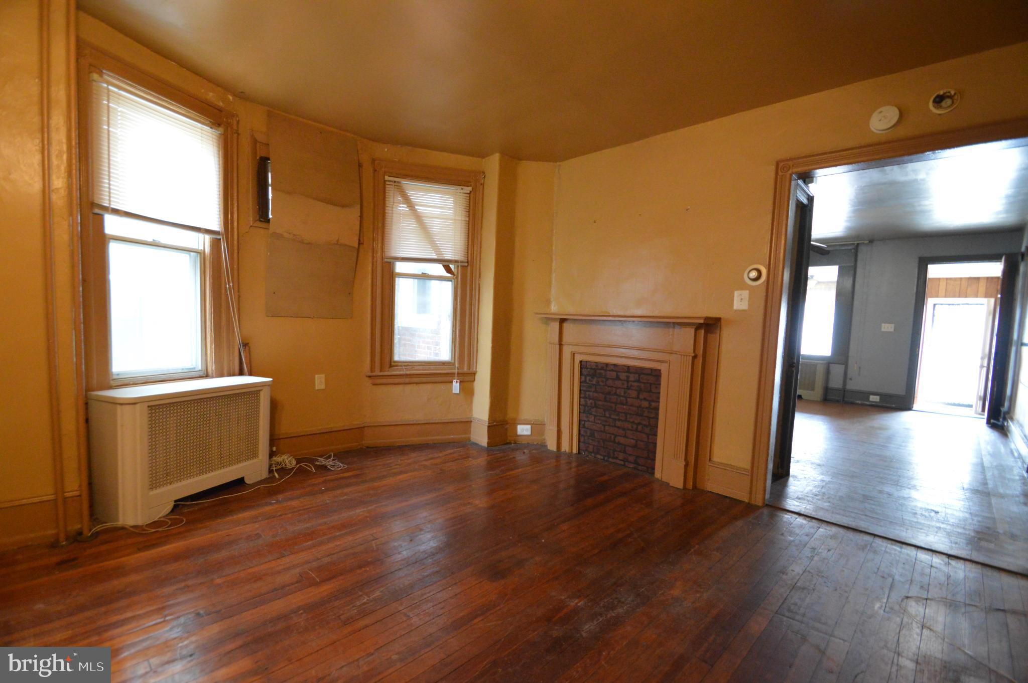 6011 Sansom Street Philadelphia, PA 19139 - Photo 5 of 24 a view of empty room with a fireplace and wooden floor