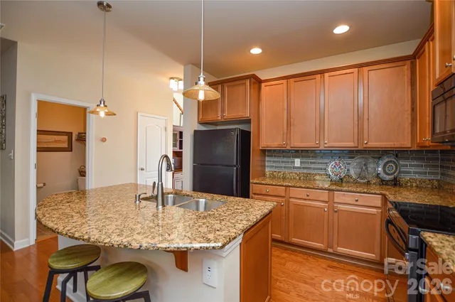 a kitchen with stainless steel appliances granite countertop a sink and a refrigerator