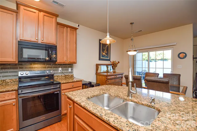 a kitchen with stainless steel appliances granite countertop a sink stove and microwave