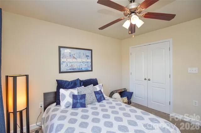 a bedroom with a large bed and a chandelier