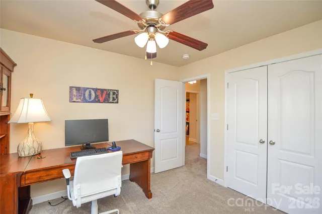 a view of a workspace with furniture and a chandelier fan