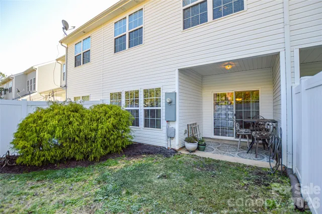 a view of backyard with a table and chairs and potted plants
