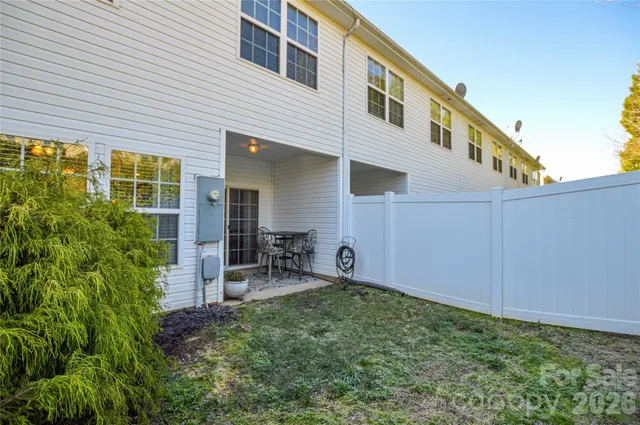 a backyard of a house with table and chairs